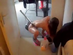 Skinny bare wife hoovering apartment wearing just a pair of pink slippers.